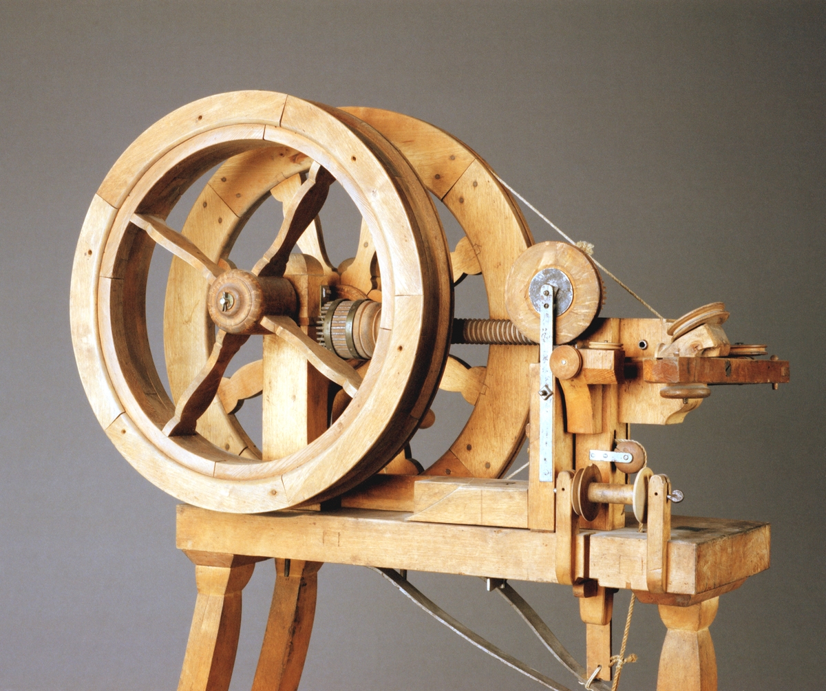 Kantiljrock. Text på föremålet: "C-c-16 ?VII.C.17." I Jonas Norbergs förteckning från 1779 beskrivs modellen på följande sätt: "Ny Invention av Cantille råck, gjord i stort, hvarpå några hundrade alnar i en längd spinnas af sig sjelf, då man drager omkring en liten vef."
