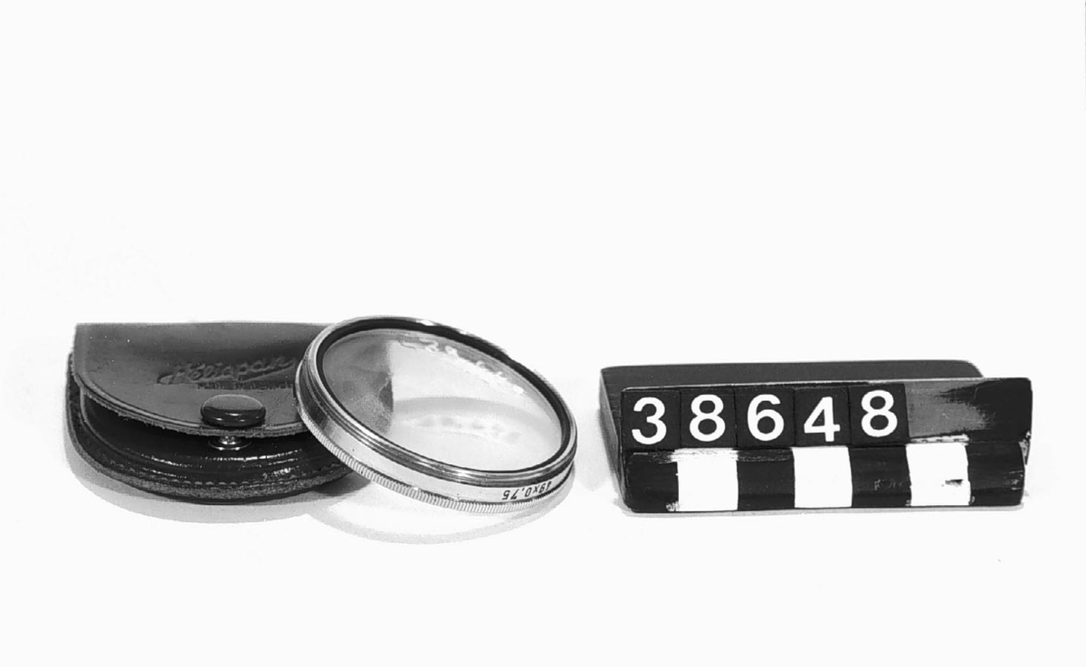 Gulfilter till Exakta-kamera. Beteckning: G2 3 x 49 x 0.75, i läderetui. Filtret märkt: A/B Exakta Agentur Stockholm. Läderetuiet märkt: Heliopan Made in Germany.
Tillbehör: Läderetui.