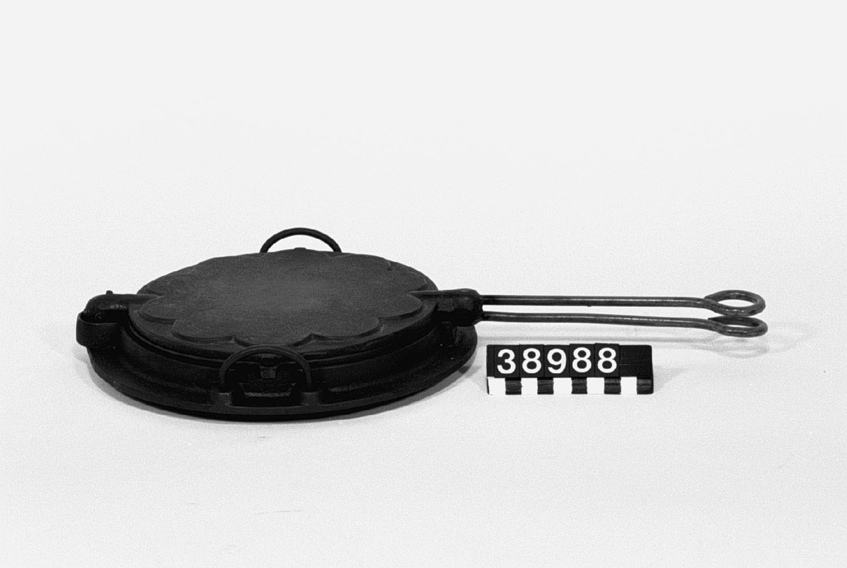 Våffeljärn för ved eller gasspis, av gjutjärn, roterande typ, med lös bottenring med handtag.