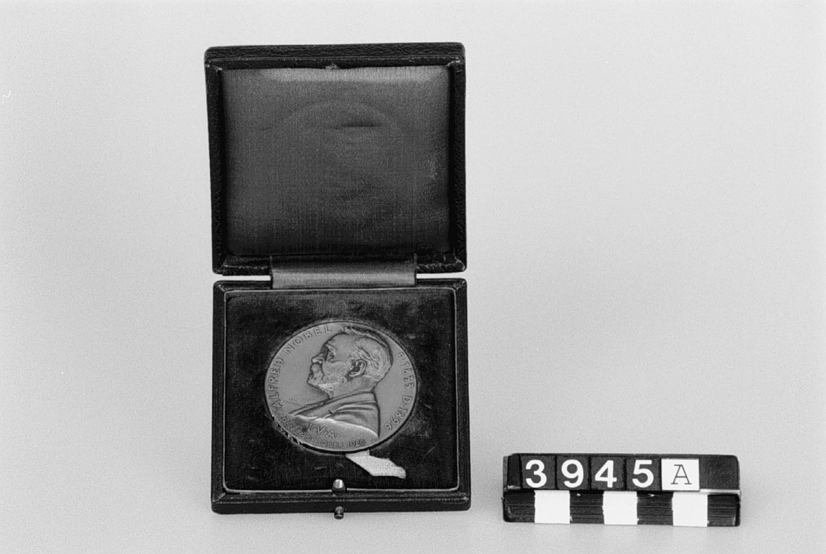 Medalj av brons i etui, slagen av Ingenjörsvetenskapsakademien över Alfred Nobel. Tjocklek: 25 mm. Åtsidan: bröstbild i lågrelief och text: "Alfred Nobel f. 1833, d. 1896. I.V.A. den 24 oktober 1926". Frånsidan: "Prometeusfigur i lågrelief. Graverad av Erik Lindberg.