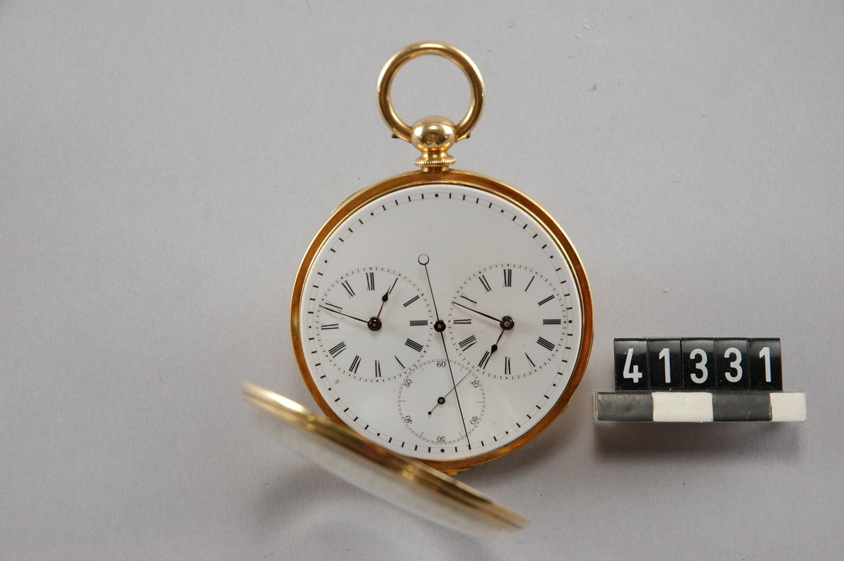Schweiziskt ankarur i guldboett. Stpl K18 24134 och 19264. Kapseln är märkt: Ligne Droite. Echappement Libre â€¦ Ancre, 23 Rubir. Spiral Braguet, Balancier Chronométre. Vit emaljtavla, två fjäderhus och dubbel uppsättning visare, springande cent-sekund. Osignerad. Ca .1860.