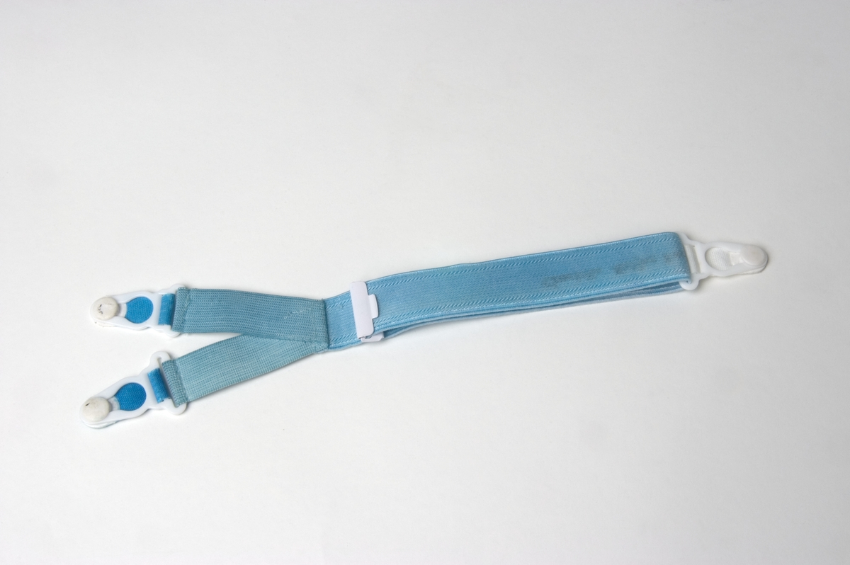 Hängsle i Y-form med knäppen i vardera tre ändar. Föremålet används för att hålla små barns kläder på plats. Övre delen av Y:et knäpps i framkant av skjorta/tröja, nedre delen av Y:et förs mellan barnets ben och knäpps i bakkant av skjorta/tröja så att detta klädesplagg hålls på plats och inte åker upp.