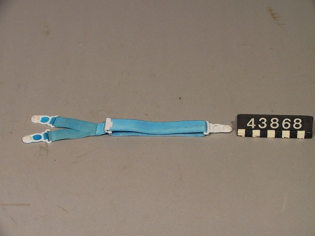 Hängsle i Y-form med knäppen i vardera tre ändar. Föremålet används för att hålla små barns kläder på plats. Övre delen av Y:et knäpps i framkant av skjorta/tröja, nedre delen av Y:et förs mellan barnets ben och knäpps i bakkant av skjorta/tröja så att detta klädesplagg hålls på plats och inte åker upp.