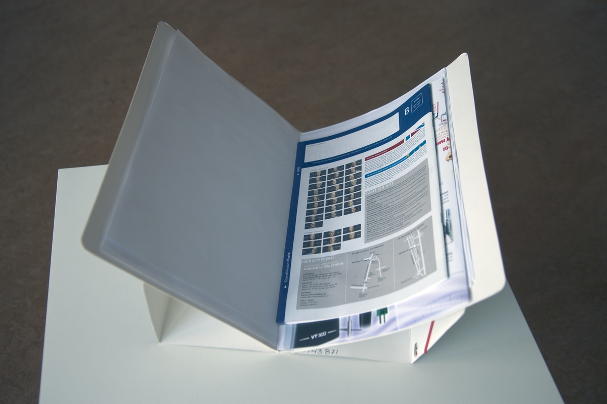 Mappen kan användas för att förvara dokument men också fungera som ett ställ som underlättar åtkomsten bland dokumenten. Stället monteras enkelt genom att ytterhöljet stöder den uppfällda innermappen.