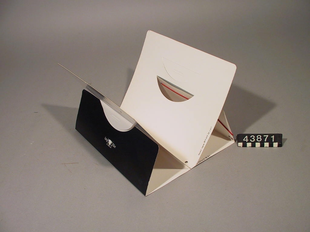 Mappen kan användas för att förvara dokument men också fungera som ett ställ som underlättar åtkomsten bland dokumenten. Stället monteras enkelt genom att ytterhöljet stöder den uppfällda innermappen.