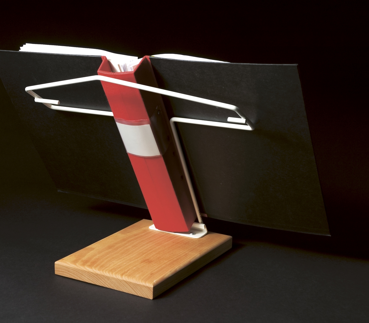 Pärmstöd som kan användas för både liggande och stående A4 pärmar. Pärmstödet består av en bockad trådställning som utgör hållare och stöd för pärmar. Stödet ger en lutning på pärmen som är gynnsam för den som arbetar länge med en pärm.