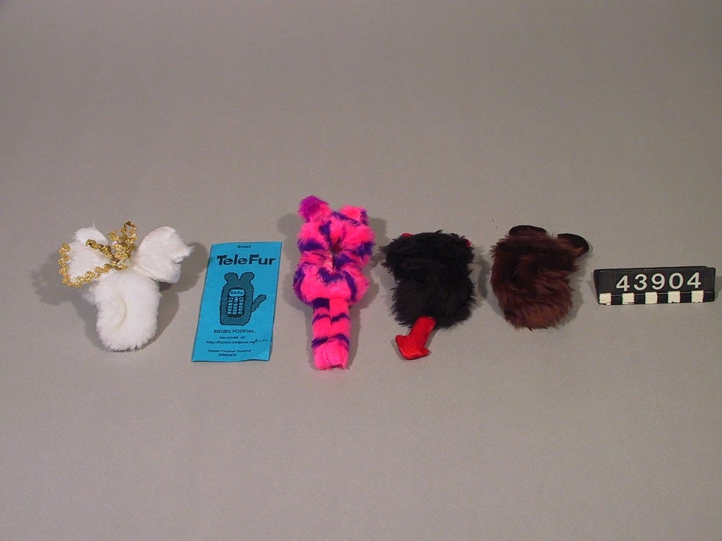 Mobiltelefonfodral i syntetpälsmaterial. Skall skydda mobilen från stötar och göra mobilen behagligare att använda när det är kallt ute.