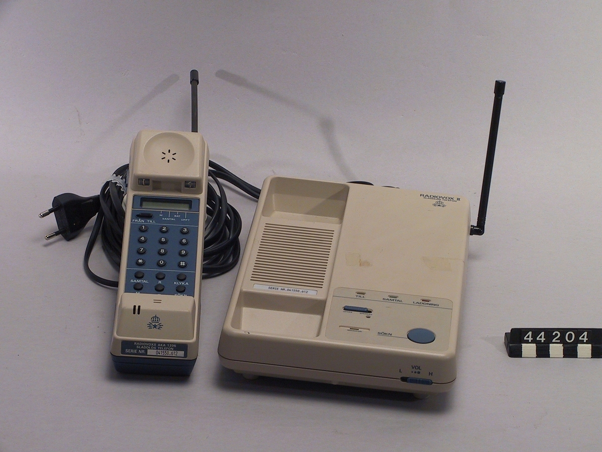 Sladdlös telefon, handtelefon och basstation, märkta med Televerkets symbol.