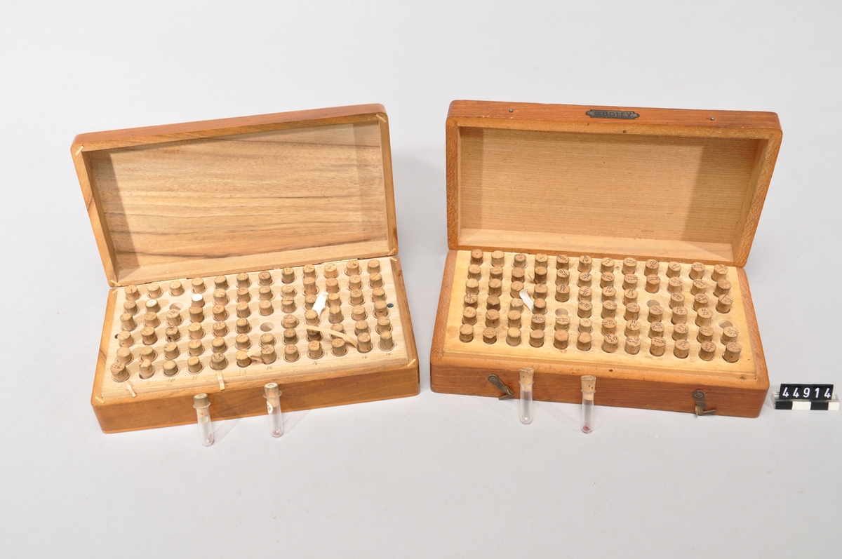 Två st trälådor av mahongny med rubiner vilka används som lager i fickur. Rubinerna ligger i glasrör.