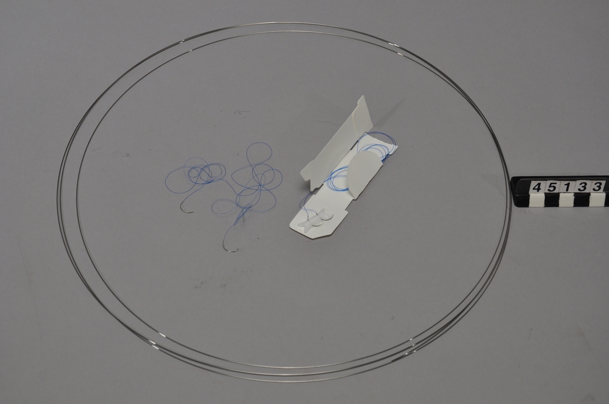 Suturnål för ögonoperationer, tillverkad i en ny typ av rostfritt stålmaterial med unika egenskaper vad gäller hårdhet och formbarhet vilket lett till en ny medicinsk produkt inom mikrokirurgi. Nålen är avsedd att användas för att sy med vid ögonoperationer utan att orsaka ärrbildning i ögat. Den omfattas av tre patent, avseende material, härdningsmekanism, applikationspatent.  Stålet utgörs av en martensitlegering men också krom, nickel, molybden, koppar, titan, aluminium, kisel, kol och kväve.Tillverkad av Sandvik.  Föremålet utgörs av en förpackning med två nålar, en tråd i stållegeringen samt separat två nålar.