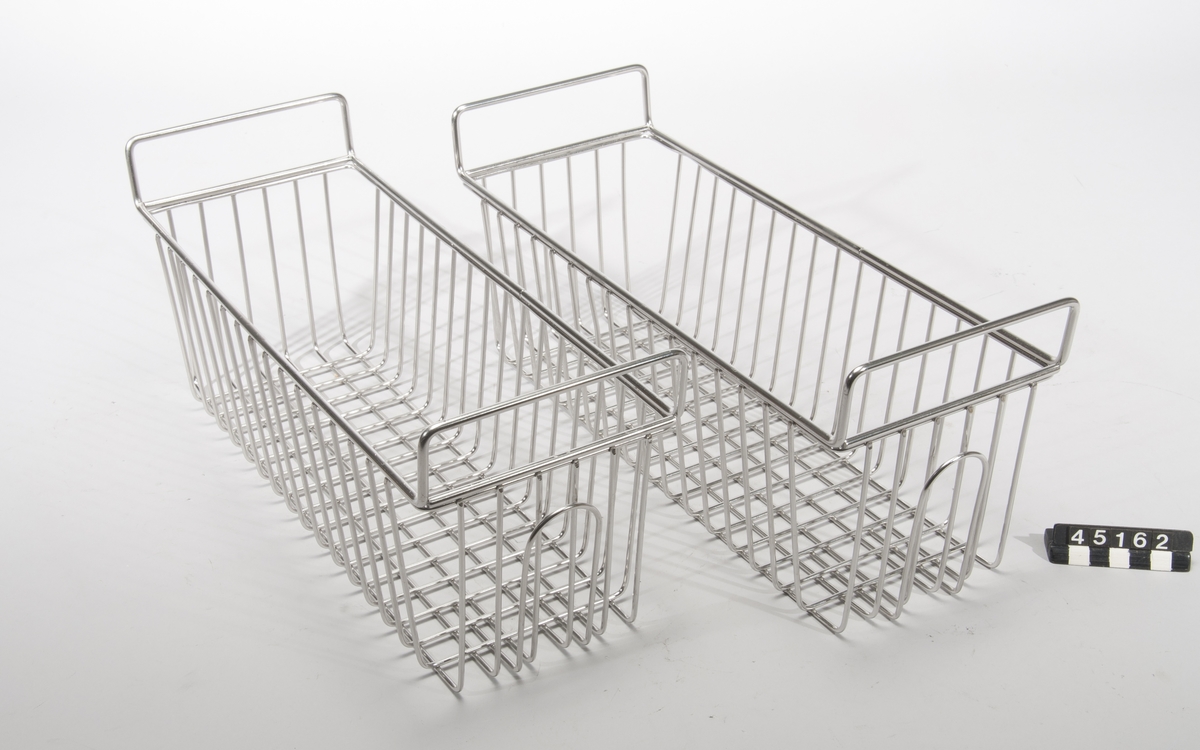 Korg för blodpåsar, två st, i rostfritt stål. Avsedd för förvaring av blod till transfusione, vilket måste förvaras svalt. En korg rymmer 10-12 blodpåsar. Korgen är lätt att hantera och kan lätt rengöras och steriliseras.  Till föremålet finns påsar med röd vätska som rekvisita.