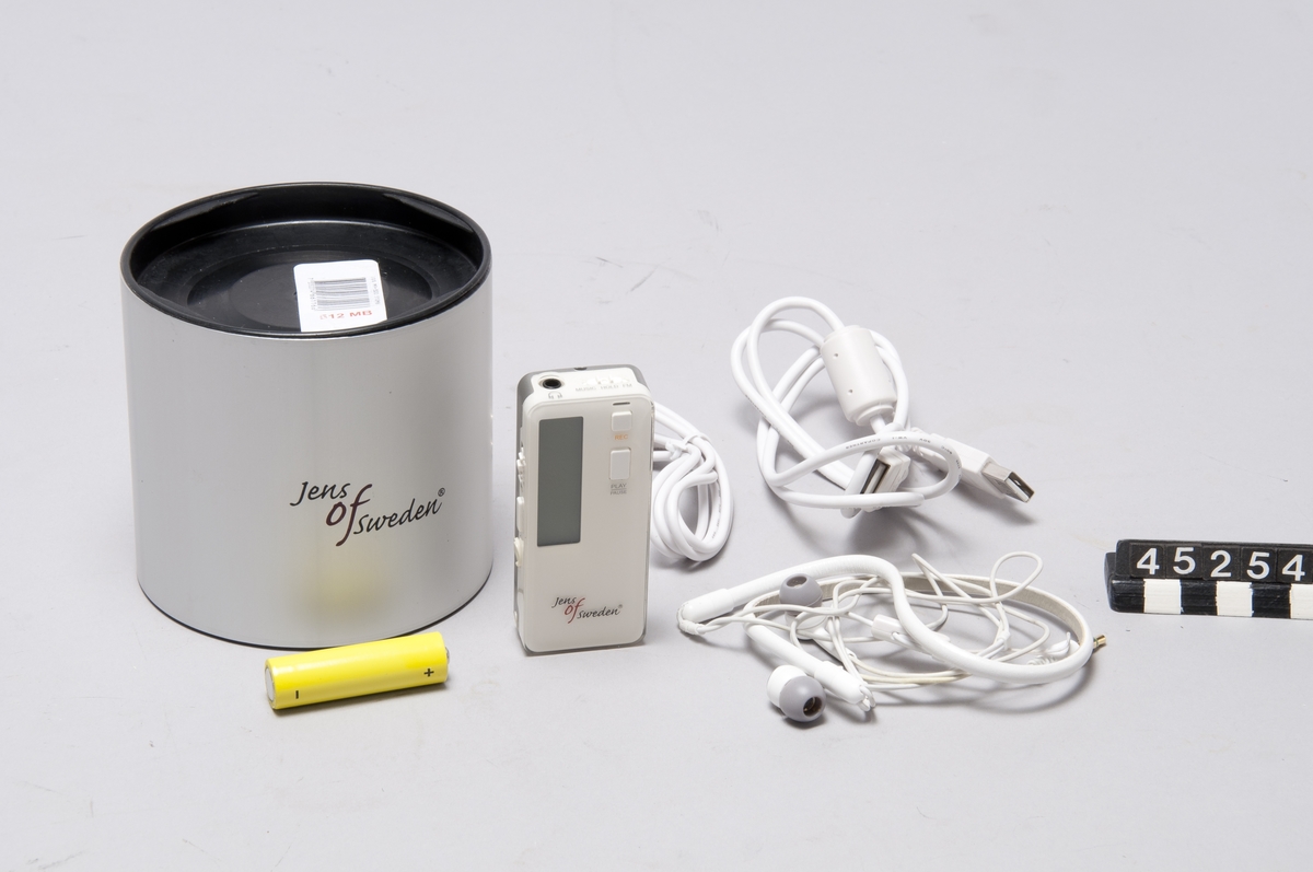 Mp3-spelare Jens of Sweden, i aluminiumrör med plastlock.  För 1 st "AA"-batteri, utskjutbar USB-anslutning. 512 MB minneskapacitet, inspelningsfunktion. Knappar för play, rec, rew/menu/ff, volume samt A-B/SPD (även märkt "FMtx"). Anslutningskablar för stereo (3,5 mm stereoplug) samt USB.  Senare kompletterad med Sony hörtelefoner typ MDR-NX1.  Denna mp3-spelare har inbyggd FM-sändare, vilket inte var tillåtet i Sverige vid tiden. Den var därför inte aktiverad i mjukvaran. Användaren kunde instalerra mjukvara för andra länder, "hacka" spelaren och därigenom slå på FM-sändaren. Då kunde man skicka ljudet till en vanlig FM-radio.
