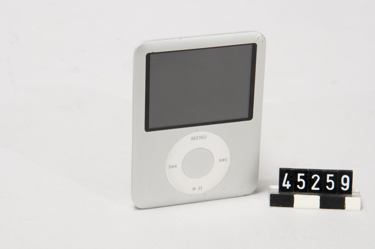 Mp3-spelare iPod Nano 4GB Model A1236 ser no 5U8229COYOP Designed by Apple in California. Assembled in China. För anslutning 5-30V likström max 1A  Enheten fylld med 3,5 GB ljudfiler Tillhörande anslutningskabel till dator, för USB-uttag