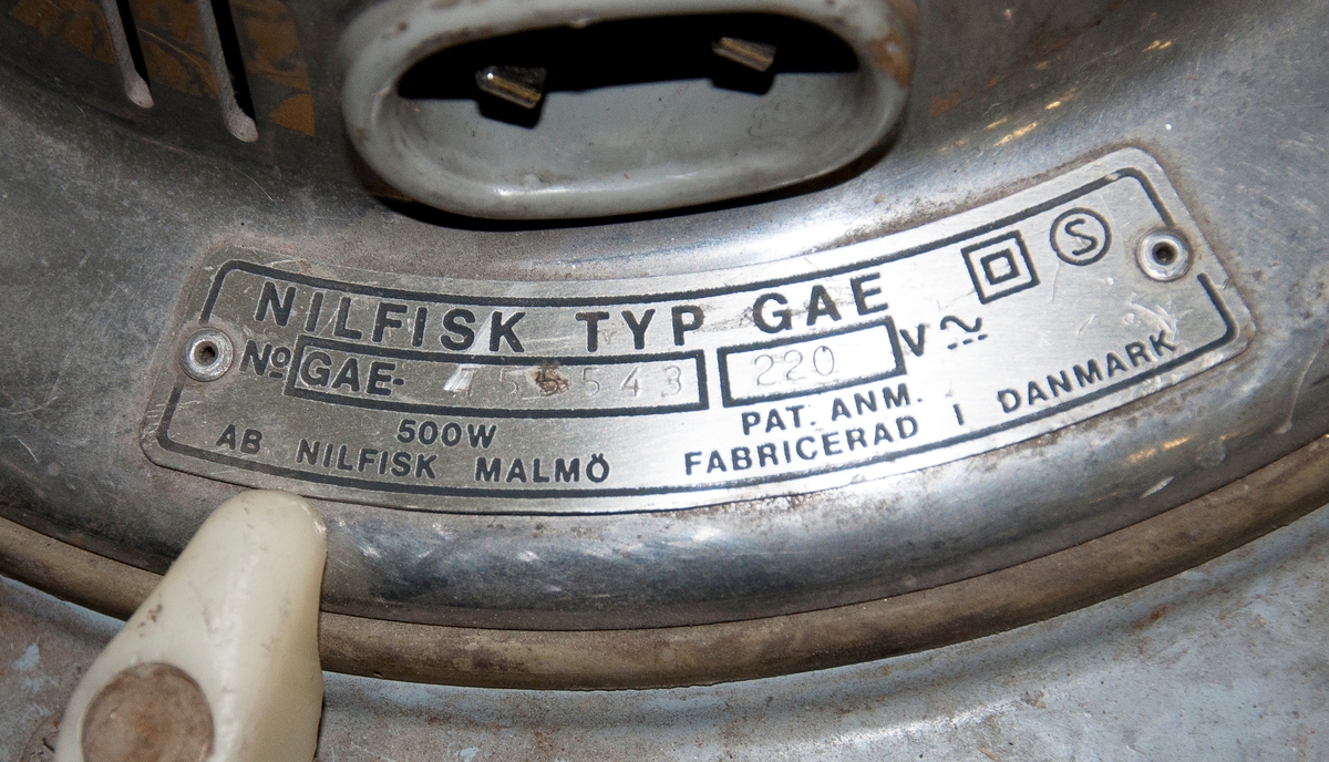 Industridammsugare Nilfisk typ GA73-7111. 
Utformad som en behållare på ställning med hjul, utrustad med tre motorer à  500 W. Motorerna är av typen GAE med serienummer 755543, 755544, 755545, ...  
Maskinen är märkt med dekal: "NBM Hydraulic, kopplingar, slangar, Karlbergs strand Solna". Även försedd med klistermärke för kopiator av märket Minolta samt parkeringstillstånd för Stockholms kommun, giltigt 1986.