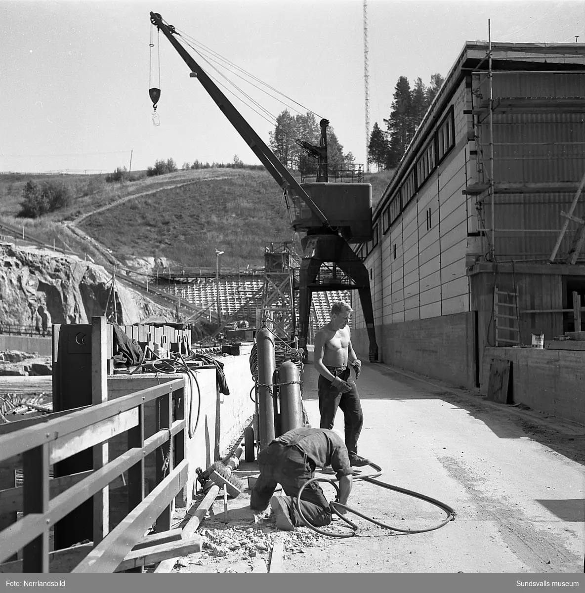 Byggnadsarbeten i och kring Järkvissle kraftverk en dryg månad innan den första generatorn togs i drift. Sista bilden är en interiörbild med typisk 1950-talsinredning, troligen från en numera riven funkisvilla som tidigare låg i anslutning till kraftverket.