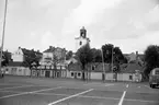 Trähus utmed Kanalgatan vid Östra Torget i Jönköping. I bakgrunden syns tornet på Kristine kyrka och i förgrunden parkeringsplatser på torget.