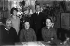 Rumsinteriör, familjegrupp fem personer.
Familjen Thörnkvist, Rickard Thörnkvist till vänster och hans fru Amalia Thörnkvist till höger.