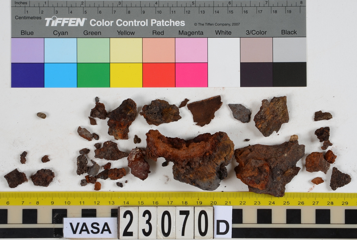 Sko.
Inuti skorna hittades även fragment från olika textilier som ursprungligen varit ett par strumpor. Idag sitter ett stickat fragment av ull fast i vänsterskon (23070) med avigsidan uppåt. I fyndet finns även en mängd lösa stickade fragment som idag är mycket korroderade och vissa helt mineraliserade av järn vilket har gjort textilen stenhård och därmed oerhört skör (23070a-c). Utifrån minskningar som några små fragment har så har det varit möjligt att rekonstruera strumpans tå. Genom att pussla ihop fragmenten som ursprungligen har suttit ihop har det på så vis gått att avgöra hur strumpans tå har varit konstruerad. Då textilen är så fragmentarisk är det inte möjligt att avgöra hur resten av strumpan har sett ut eller varit konstruerad. Däremot så finns det fragment av ett kypertvävt tyg av ull som på vissa ställen ligger dubbelt med det stickade 23070c). Ett av dessa fragment har stelnat i formen så som den suttit på fotens främre del inuti skon. Detta fragment täcker delvis det stickade tyget och har dessutom spår av kaststygn längs en kant. Så som det vävda tyget är placerat på det stickade tyget pekar på att man använt det som lagningslappar till sina stickade strumpor. 
I fyndet finns det även korroderade järnklumpar, ett tuskaftsvävt tyg av ull och rester av ett grovt bastfibergarn och två mindre läderfragment (23070d-f). Det är möjligt att även dessa har tillhört strumpan och/eller skon.

För mer detaljerad information från textildokumentationen (år 2022) se länkade filer.

Skodokumentation 2022:
Ovanläder. Tillverkad i getskinn av god kvalitet. Hör ihop med fyndnummer 23069 (Yngves skor). Tillverkades på en rak läst och bars på vänster fot. Inga dekorationer Det finns stygnhål som visar att det funnits invändiga förstärkningar (men förstärkningslappen saknas). Det finns delaminering men inga lagningar.
För mer information, se Länkade filer: Uppritning

Text in english:
This is the upper of a shoe of more “extreme fashion”, made of goatskin leather of good quality, probably made on a straight last and worn of the left foot, with no decorative features. The upper couples with 23069, together composing Yngve’s shoes. There are internal reinforcements missing from the upper and delamination, there are no repairs.
For more information, go to Länkade filer: Uppritning