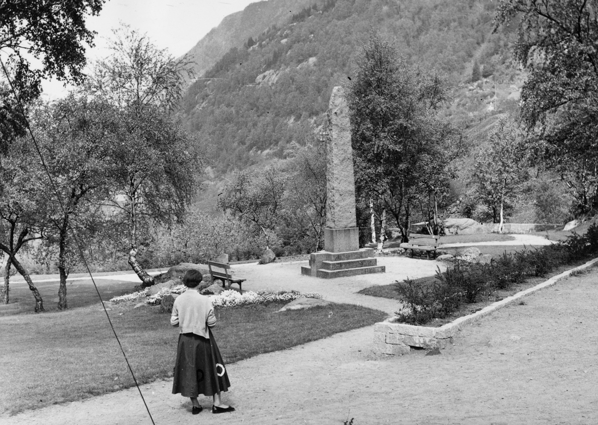 Kvinne spaserar i parkanlegg ved Albert Petersson-bautaen ved Monso.