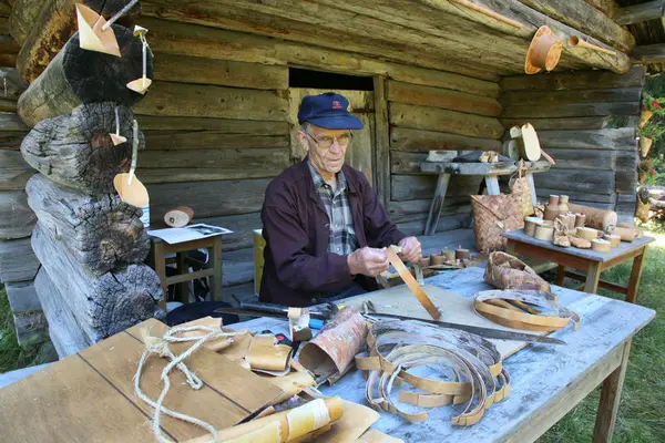 Mann som sitter på finnetunet og jobber med neverarbeider.