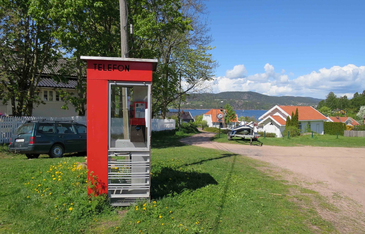 This is the story of how Norway’s most important conversation-space was designed by a young, freshly graduated man from Bergen.

“Norwegian architects are hereby invited…”
In the autumn of 1932, Oslo Telefonanlegginitiated an architectural competition. Finally, Oslo would get its own telephone booth. The city had had so called “talking-stations” from 1885, which in turn were overtaken by automatic telephones 
 only available at selected Narvesen kiosks. The state 
was of the opinion that now was the time to offer the public a better service; public telephone booths open 24/7, like the ones they already had in Sweden and England. But what would they look like, these new telephone booths? What considerations would it
 be necessary to take when designing it? The telegraph board developed a detailed list of demands and restraints: “The booth is intended to be placed outside on the streets and squares and need to be designed so that snow and ice does not hinder the opening and closing of the doors,” they wrote. “To prevent vandalism, theft, uncleanliness etc. inside the booth, it needs to be designed so that from all angles one may see what is going on in there.” Additionally, it would need to withstand storms and bad weather, and “preferably also being whipped by rain mixed with seawater” 

This was not all: The appearance would have to be «pleasing». The booth also needed to be movable, so that it could be taken in to be serviced at Telegrafverket’s main workshops. The reqired material was iron, and the surface was to be spray painted  preferably using car-body paint. There was a requirement for “a writing shelf, a pack shelf, and a suitable place for the telephone catalogue.” Also, there would need to be an illuminated TELEFON  sign, easily visible from all four angles. The total cost for each booth should not exceed 1000 kroner. The first prize for coming up with such a product was 800 kroner.

“Norwegianarchitects are hereby invited to partake in a competition for the design of a telephone booth…”  

The man with the solution
«At some point in 1932, Georg Fredrik sat at a party in Bergen. Maybe he felt a bit lost and forgotten as he often had throughout his life. He retreated to a quiet corner, took out a pencil and strted doodling on a matchbox.  According to my mother, this was how the telephone booth came into being.” In the book “Norges lille røde  historien om telefonkiosken,” Lars Fasting describes his father, the man who is far less known than the iconic architctural structure he left behind. Georg Fredrik Fasting was from Bergen, born into a family of working people and smallholders. One unusual facet of Georg Fredrik was that he was born without ears. His mother made sure he learnt to speak, read and write, 
ut Lars Fasting indicates that his father would seek refuge in drawing when the social challenges became too much to bear. And in the end drawing became his profession. In 1924 he secured a guarantor for a student loan, and started studying to become an a
rchitect at the NTH. Throughout the 1930s he entered several architectural competitions, with drafts produced, according to his son, “after work and in the late hours of the night.”

His efforts were not wasted. Out of 93 entries, with names such as “Flirt”, “Brrr”, “Ring” and “Amor”, the jury selected Fasting’s submission, “RIKS” as the new telephone booth: “The draft shows a strikingly simple solution to the task, technically as well as aesthetically well worked out.”

Taut and provident
Simple and aesthetc are the keywords here. Fasting had designed a booth pointing towards the future, and to modernism. Just how modern it was can be seen by comparing RIKS to the British telephone booth, also designed in the interwar-era. While the British version with it classicistic style is looking back to the heyday of the empire, Fasting’s booth is progressive and functionalistic. Like most Norwegian architects, Fasting broke with the classicistic style of architecture after the Stockholm-exhibition in 1930. “After it, almost all buildings erected in Norway until the German invasion in 1940, were in the functionalistic architectural style,” writes senior curator of architecture at the Norwegian National Museum, Ulf Grønvold, in the book, “Den lille røde”.“TheNorwegian booth is a piece of functionalistic architecture, an asymmetric composition with its roof slab overhanging the word TELEFON, in bold sans seraph lettering,”concludes Ulf Grønvold.

Fashionably red
And it was red. Fasting chose a colour which was part of the modern palette. “A bright red colour, but not as shiny as a signal red, the character of the colour places it among the fashionable colours within functionalism,” states paintings conservator and researcher in NIKU (Norwegian Institute for Cultural Heitage Research), Jon Brænne. In his opinion, Fasting went for visibility without making the booth stand out too much from its surroundings. The original colour was in use up to around 1950, when it changed to signal red. Towards the end of the 1970s the clour was again adjusted towards today’s orangey red.

The design, however, has not changed. RIKS is eighty years and still looks remarkably good. That’s what makes Fasting’s telephone booth a classic  even before it was added to DOCOMOMO’s list over moden icons of design. For Telenor, the telephone booth has served as a pathway into the hearts of the public. For many, Telenor (Televerket) was synonymous with exactly this telephone booth, because this was where one would go to place a call. Having a home
phone was not common until the 1980s. As such the red box became part of the Norwegian everyday and consciousness. The symbol- and publicity value of this is hard to evaluate, but in 2007 it was time to give honour where honour was due, Telenor, in consul
tation with the Directorate for Cultural Heritage, decided to preserve 100 telephone booths for all eternity.

And what about Georg Fredrik Fasting? What happened to him? At the age of 56 an entry in his diary states: «I CAN HEAR». As the first person in th world he had undergone an operation where he had ear canals constructed and eardrums fitted. For the rest of his life, the man behind Norway’s own telephone booth could answer the telephone himself.

Source: Norges lille røde historien om telefonkiosken (2007), issued by The Norwegian Telecom Museum and Telenor Cultural Heritage.