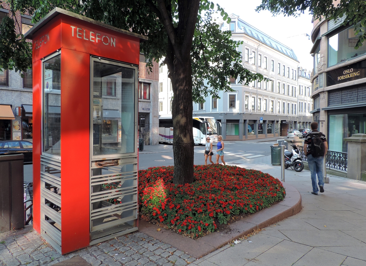 This is the story of how Norway’s most important conversation-space was designed by a young, freshly graduated man from Bergen.

“Norwegian architects are hereby invited…”
In the autumn of 1932, Oslo Telefonanlegginitiated an architectural competition. Finally, Oslo would get its own telephone booth. The city had had so called “talking-stations” from 1885, which in turn were overtaken by automatic telephones 
 only available at selected Narvesen kiosks. The state 
was of the opinion that now was the time to offer the public a better service; public telephone booths open 24/7, like the ones they already had in Sweden and England. But what would they look like, these new telephone booths? What considerations would it
 be necessary to take when designing it? The telegraph board developed a detailed list of demands and restraints: “The booth is intended to be placed outside on the streets and squares and need to be designed so that snow and ice does not hinder the opening and closing of the doors,” they wrote. “To prevent vandalism, theft, uncleanliness etc. inside the booth, it needs to be designed so that from all angles one may see what is going on in there.” Additionally, it would need to withstand storms and bad weather, and “preferably also being whipped by rain mixed with seawater” 

This was not all: The appearance would have to be «pleasing». The booth also needed to be movable, so that it could be taken in to be serviced at Telegrafverket’s main workshops. The reqired material was iron, and the surface was to be spray painted  preferably using car-body paint. There was a requirement for “a writing shelf, a pack shelf, and a suitable place for the telephone catalogue.” Also, there would need to be an illuminated TELEFON  sign, easily visible from all four angles. The total cost for each booth should not exceed 1000 kroner. The first prize for coming up with such a product was 800 kroner.

“Norwegianarchitects are hereby invited to partake in a competition for the design of a telephone booth…”  

The man with the solution
«At some point in 1932, Georg Fredrik sat at a party in Bergen. Maybe he felt a bit lost and forgotten as he often had throughout his life. He retreated to a quiet corner, took out a pencil and strted doodling on a matchbox.  According to my mother, this was how the telephone booth came into being.” In the book “Norges lille røde  historien om telefonkiosken,” Lars Fasting describes his father, the man who is far less known than the iconic architctural structure he left behind. Georg Fredrik Fasting was from Bergen, born into a family of working people and smallholders. One unusual facet of Georg Fredrik was that he was born without ears. His mother made sure he learnt to speak, read and write, 
ut Lars Fasting indicates that his father would seek refuge in drawing when the social challenges became too much to bear. And in the end drawing became his profession. In 1924 he secured a guarantor for a student loan, and started studying to become an a
rchitect at the NTH. Throughout the 1930s he entered several architectural competitions, with drafts produced, according to his son, “after work and in the late hours of the night.”

His efforts were not wasted. Out of 93 entries, with names such as “Flirt”, “Brrr”, “Ring” and “Amor”, the jury selected Fasting’s submission, “RIKS” as the new telephone booth: “The draft shows a strikingly simple solution to the task, technically as well as aesthetically well worked out.”

Taut and provident
Simple and aesthetc are the keywords here. Fasting had designed a booth pointing towards the future, and to modernism. Just how modern it was can be seen by comparing RIKS to the British telephone booth, also designed in the interwar-era. While the British version with it classicistic style is looking back to the heyday of the empire, Fasting’s booth is progressive and functionalistic. Like most Norwegian architects, Fasting broke with the classicistic style of architecture after the Stockholm-exhibition in 1930. “After it, almost all buildings erected in Norway until the German invasion in 1940, were in the functionalistic architectural style,” writes senior curator of architecture at the Norwegian National Museum, Ulf Grønvold, in the book, “Den lille røde”.“TheNorwegian booth is a piece of functionalistic architecture, an asymmetric composition with its roof slab overhanging the word TELEFON, in bold sans seraph lettering,”concludes Ulf Grønvold.

Fashionably red
And it was red. Fasting chose a colour which was part of the modern palette. “A bright red colour, but not as shiny as a signal red, the character of the colour places it among the fashionable colours within functionalism,” states paintings conservator and researcher in NIKU (Norwegian Institute for Cultural Heitage Research), Jon Brænne. In his opinion, Fasting went for visibility without making the booth stand out too much from its surroundings. The original colour was in use up to around 1950, when it changed to signal red. Towards the end of the 1970s the clour was again adjusted towards today’s orangey red.

The design, however, has not changed. RIKS is eighty years and still looks remarkably good. That’s what makes Fasting’s telephone booth a classic  even before it was added to DOCOMOMO’s list over moden icons of design. For Telenor, the telephone booth has served as a pathway into the hearts of the public. For many, Telenor (Televerket) was synonymous with exactly this telephone booth, because this was where one would go to place a call. Having a home
phone was not common until the 1980s. As such the red box became part of the Norwegian everyday and consciousness. The symbol- and publicity value of this is hard to evaluate, but in 2007 it was time to give honour where honour was due, Telenor, in consul
tation with the Directorate for Cultural Heritage, decided to preserve 100 telephone booths for all eternity.

And what about Georg Fredrik Fasting? What happened to him? At the age of 56 an entry in his diary states: «I CAN HEAR». As the first person in th world he had undergone an operation where he had ear canals constructed and eardrums fitted. For the rest of his life, the man behind Norway’s own telephone booth could answer the telephone himself.

Source: Norges lille røde historien om telefonkiosken (2007), issued by The Norwegian Telecom Museum and Telenor Cultural Heritage.