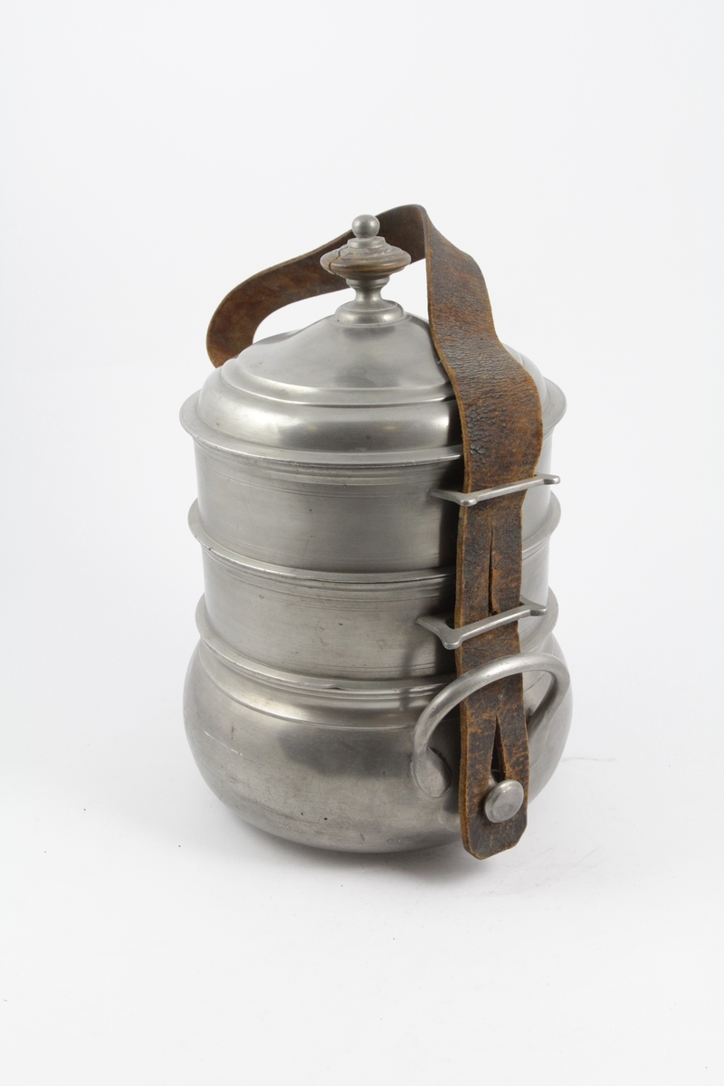 Matspann av fire deler og bærerem. 

a: Beholder. Nederste. Sirkelrund bunn med lav fotring, utbuket side, innsnevret rand. To bøyleformede hanker over snelleformet knapp. 

b: Beholder. Midtre. Sirkelrund. Svakt hvelvet bunn, med horisontal kant. vertikal side profilert ved kanten, og forsynt med to rettvinklede ører. 

c: Beholder. Som b. 

d: Lokk. Sirkelrundt, hvelvet, prydet med to konsentriske linjer, horisontal kant og dreiet knapp av tinn og tre. 

e: Rem. til å bære og forbinde delene. Lær, brun, flat med fire spaltelignende hull.