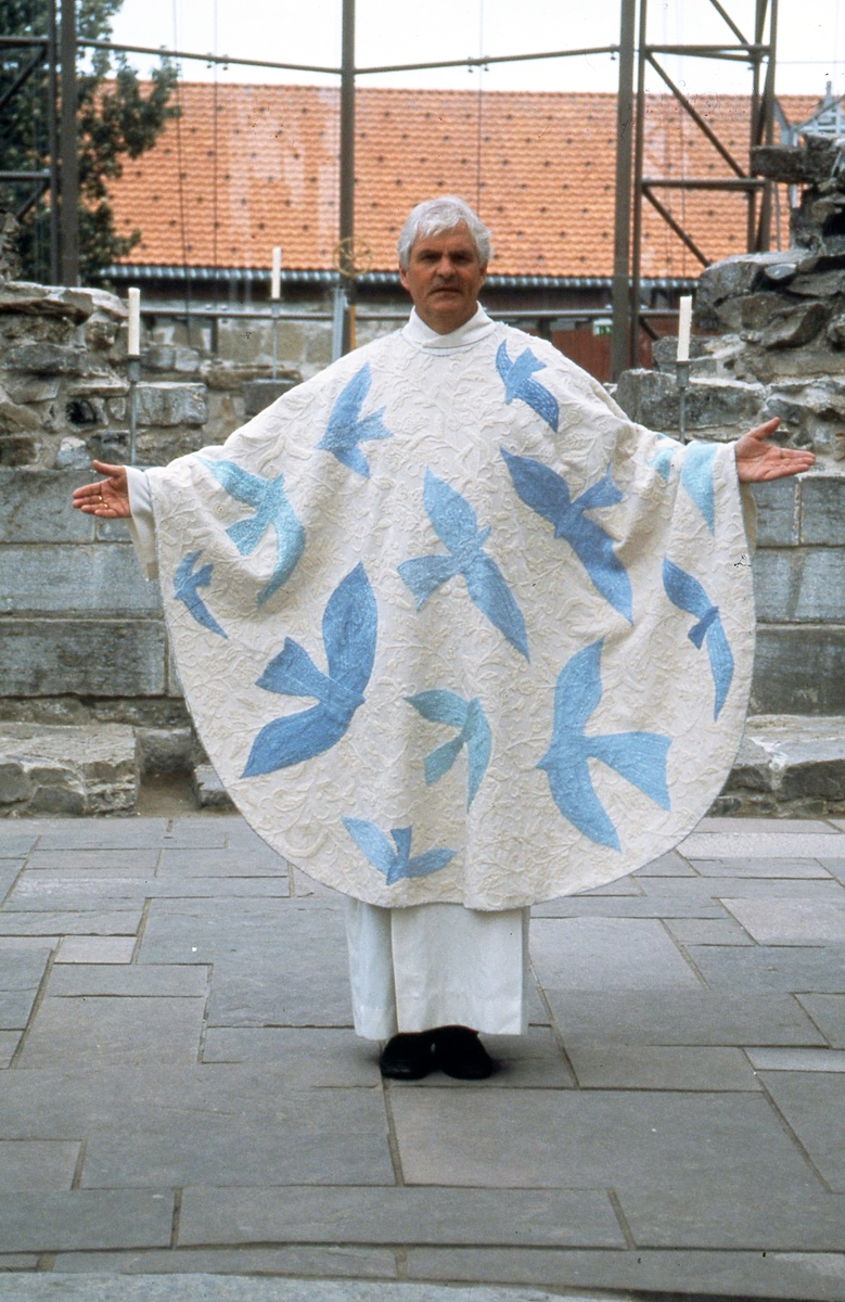 Ett av tre verk. Verket er håndvevet i naturhvit bomull med ullbroderier. Broderiene er laget i moulinegarn i ulike blåtoner, sølv og gull.
Messehakelens hovedfarge er hvit med broderier av blå duer og svaler, på baksiden et kors i gull. 
Duen er det viktigste symbolet på den Hellige Ånd og den eneste fuglen som ble brukt ved de gammeltestamentlige ofringene. Duen ved Jesu dåp skal symbolisere at syndens makt er brutt. Svalen kalles ofte Mariafuglen og det sies at svalen kommer om våren på Jomfru Marias bebudelsesdag 25 mars, og reiser på hennes fødselsdag 8 september. Ved kirkeinnvielser står blått for himlens og havets farge og leder tanken hen på det overjordiske, det guddommelige, og trofastheten.