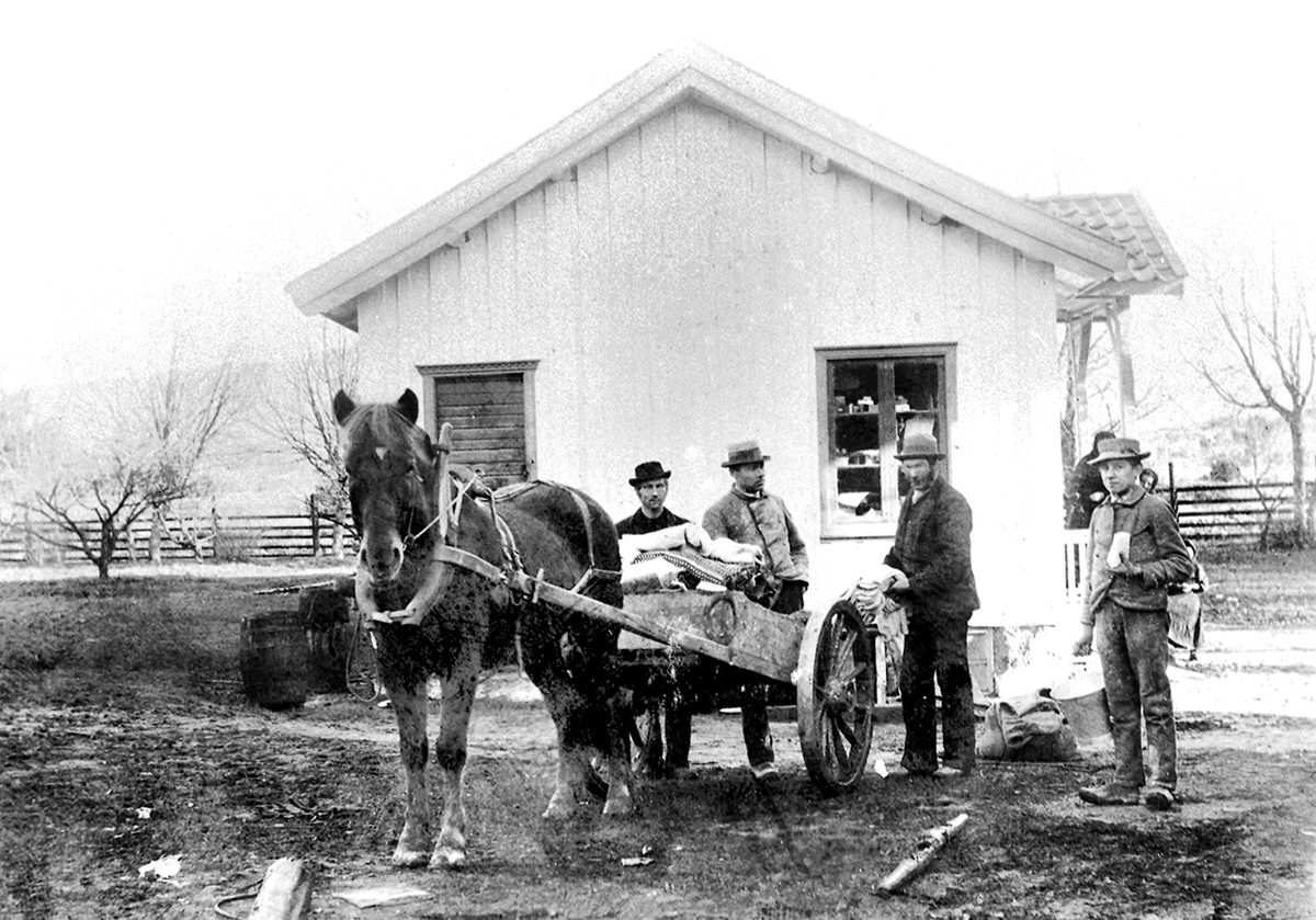 "Paul (Pål) Skoe sel ullvarer frå Flekkefjord Ullvarefabrikk. Frå v. Gunlek H. Kalbekk el. Moen, Halvor G. Sisjord, Pål Skoe og H. Olsen Haugen." (Skrive av Ingeborg H. Sisjord).  
Bildet er tatt utanfor den gamle landhandelen bygd av T. Tovsen på Løvlund
