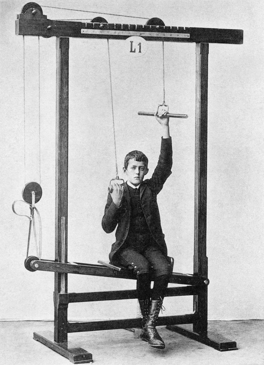Gosse i högt snörade kängor tränar bålbalans och armsträckning.

English:
This boy in high-laced boots is benefiting from some arm-stretching while working on the balance of his torso.