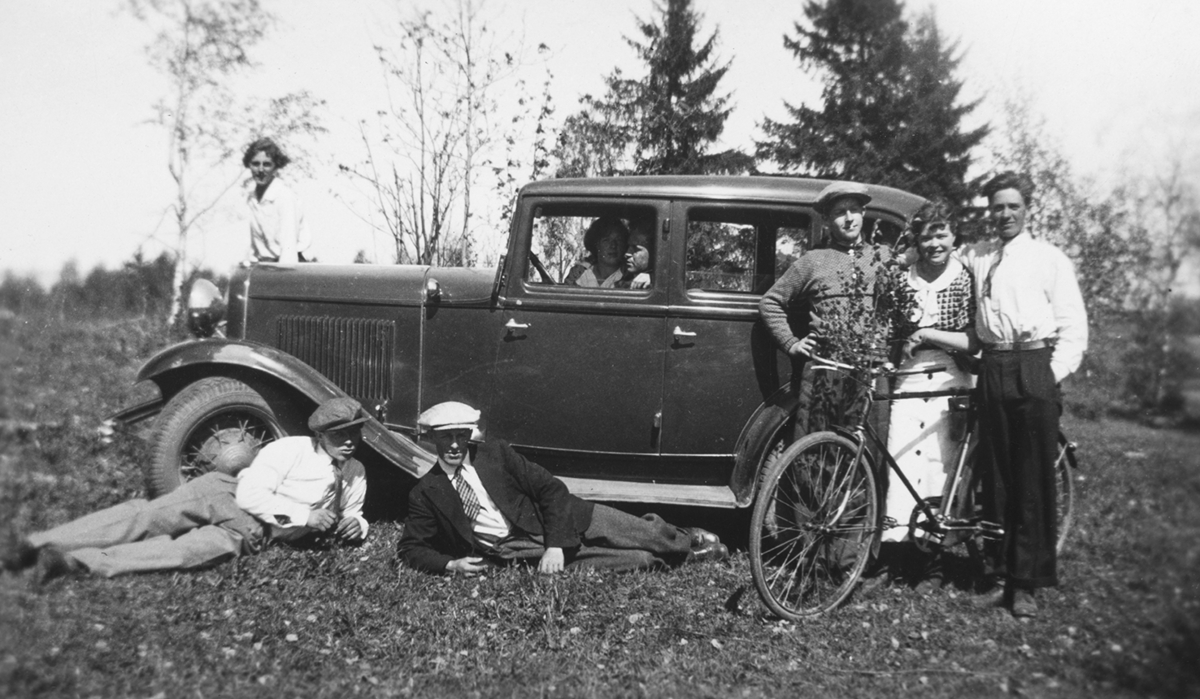 Ottestad 1936. F.v Odvar Hagelund, Aksel Myhre, Trygve Myhre, Else  Solberg, Einar Hagelund, inne i bilen Tilla Myhre, Lenhart Nerhagen, på bilpanseret Ester Holmsveen. Personbil,Ford B eller V8 1932. sykkel.