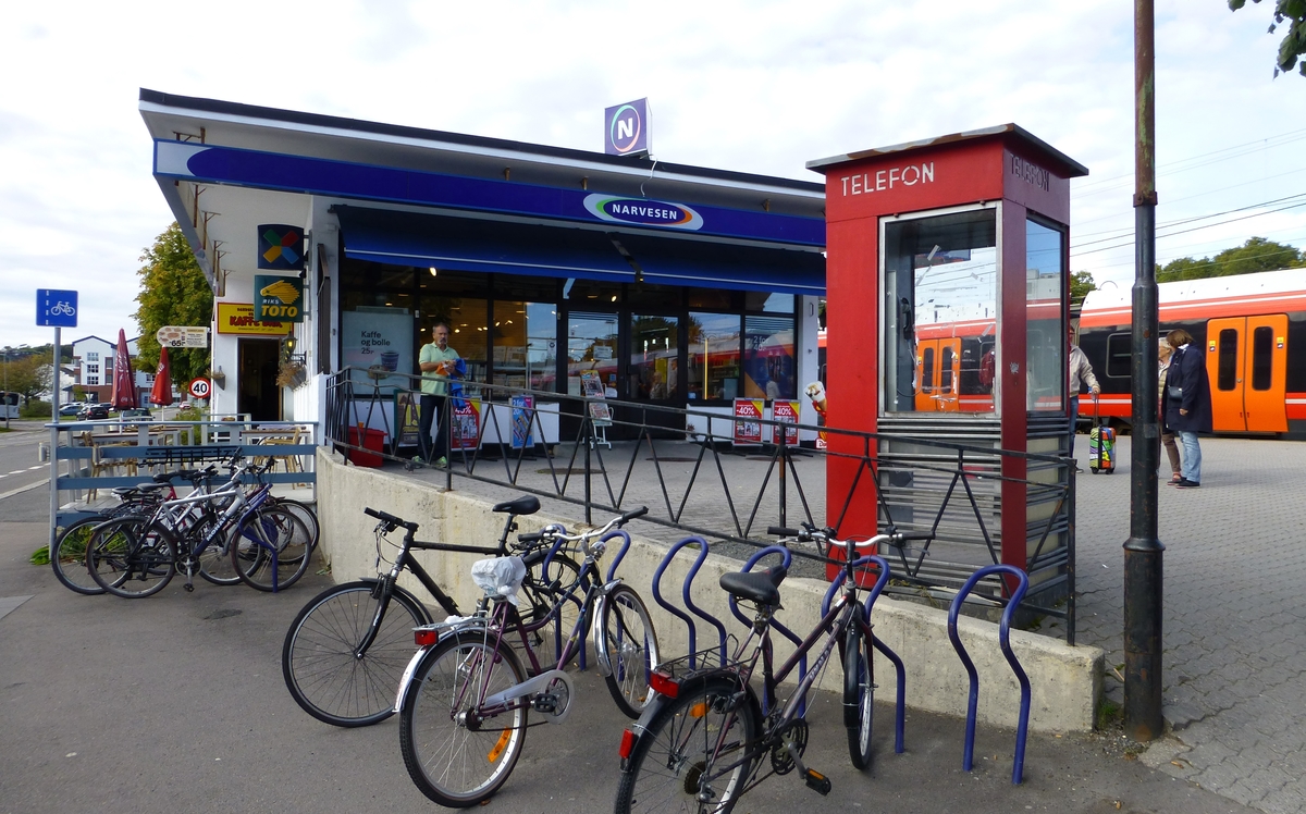 This is the story of how Norway’s most important conversation-space was designed by a young, freshly graduated man from Bergen.

“Norwegian architects are hereby invited…”
In the autumn of 1932, Oslo Telefonanlegginitiated an architectural competition. Finally, Oslo would get its own telephone booth. The city had had so called “talking-stations” from 1885, which in turn were overtaken by automatic telephones 
 only available at selected Narvesen kiosks. The state 
was of the opinion that now was the time to offer the public a better service; public telephone booths open 24/7, like the ones they already had in Sweden and England. But what would they look like, these new telephone booths? What considerations would it
 be necessary to take when designing it? The telegraph board developed a detailed list of demands and restraints: “The booth is intended to be placed outside on the streets and squares and need to be designed so that snow and ice does not hinder the opening and closing of the doors,” they wrote. “To prevent vandalism, theft, uncleanliness etc. inside the booth, it needs to be designed so that from all angles one may see what is going on in there.” Additionally, it would need to withstand storms and bad weather, and “preferably also being whipped by rain mixed with seawater” 

This was not all: The appearance would have to be «pleasing». The booth also needed to be movable, so that it could be taken in to be serviced at Telegrafverket’s main workshops. The reqired material was iron, and the surface was to be spray painted  preferably using car-body paint. There was a requirement for “a writing shelf, a pack shelf, and a suitable place for the telephone catalogue.” Also, there would need to be an illuminated TELEFON  sign, easily visible from all four angles. The total cost for each booth should not exceed 1000 kroner. The first prize for coming up with such a product was 800 kroner.

“Norwegianarchitects are hereby invited to partake in a competition for the design of a telephone booth…”  

The man with the solution
«At some point in 1932, Georg Fredrik sat at a party in Bergen. Maybe he felt a bit lost and forgotten as he often had throughout his life. He retreated to a quiet corner, took out a pencil and strted doodling on a matchbox.  According to my mother, this was how the telephone booth came into being.” In the book “Norges lille røde  historien om telefonkiosken,” Lars Fasting describes his father, the man who is far less known than the iconic architctural structure he left behind. Georg Fredrik Fasting was from Bergen, born into a family of working people and smallholders. One unusual facet of Georg Fredrik was that he was born without ears. His mother made sure he learnt to speak, read and write, 
ut Lars Fasting indicates that his father would seek refuge in drawing when the social challenges became too much to bear. And in the end drawing became his profession. In 1924 he secured a guarantor for a student loan, and started studying to become an a
rchitect at the NTH. Throughout the 1930s he entered several architectural competitions, with drafts produced, according to his son, “after work and in the late hours of the night.”

His efforts were not wasted. Out of 93 entries, with names such as “Flirt”, “Brrr”, “Ring” and “Amor”, the jury selected Fasting’s submission, “RIKS” as the new telephone booth: “The draft shows a strikingly simple solution to the task, technically as well as aesthetically well worked out.”

Taut and provident
Simple and aesthetc are the keywords here. Fasting had designed a booth pointing towards the future, and to modernism. Just how modern it was can be seen by comparing RIKS to the British telephone booth, also designed in the interwar-era. While the British version with it classicistic style is looking back to the heyday of the empire, Fasting’s booth is progressive and functionalistic. Like most Norwegian architects, Fasting broke with the classicistic style of architecture after the Stockholm-exhibition in 1930. “After it, almost all buildings erected in Norway until the German invasion in 1940, were in the functionalistic architectural style,” writes senior curator of architecture at the Norwegian National Museum, Ulf Grønvold, in the book, “Den lille røde”.“TheNorwegian booth is a piece of functionalistic architecture, an asymmetric composition with its roof slab overhanging the word TELEFON, in bold sans seraph lettering,”concludes Ulf Grønvold.

Fashionably red
And it was red. Fasting chose a colour which was part of the modern palette. “A bright red colour, but not as shiny as a signal red, the character of the colour places it among the fashionable colours within functionalism,” states paintings conservator and researcher in NIKU (Norwegian Institute for Cultural Heitage Research), Jon Brænne. In his opinion, Fasting went for visibility without making the booth stand out too much from its surroundings. The original colour was in use up to around 1950, when it changed to signal red. Towards the end of the 1970s the clour was again adjusted towards today’s orangey red.

The design, however, has not changed. RIKS is eighty years and still looks remarkably good. That’s what makes Fasting’s telephone booth a classic  even before it was added to DOCOMOMO’s list over moden icons of design. For Telenor, the telephone booth has served as a pathway into the hearts of the public. For many, Telenor (Televerket) was synonymous with exactly this telephone booth, because this was where one would go to place a call. Having a home
phone was not common until the 1980s. As such the red box became part of the Norwegian everyday and consciousness. The symbol- and publicity value of this is hard to evaluate, but in 2007 it was time to give honour where honour was due, Telenor, in consul
tation with the Directorate for Cultural Heritage, decided to preserve 100 telephone booths for all eternity.

And what about Georg Fredrik Fasting? What happened to him? At the age of 56 an entry in his diary states: «I CAN HEAR». As the first person in th world he had undergone an operation where he had ear canals constructed and eardrums fitted. For the rest of his life, the man behind Norway’s own telephone booth could answer the telephone himself.

Source: Norges lille røde historien om telefonkiosken (2007), issued by The Norwegian Telecom Museum and Telenor Cultural Heritage.
