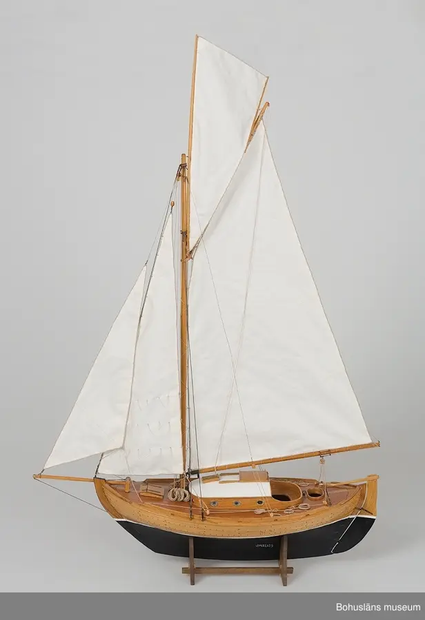 Modell av klinkbyggd kosterbåt. Gaffelriggad med bogspröt och segel, däckad och ruffad. Svartmålad botten. Detaljrik.
På styrbords kölsida, aktern, signerat med vita bokstäver:
Bengt Pettersson 2002
Påskrift midskepps:
ZAIMA
SS FRAM 1919

Ställ tillhör, ingår ej i måttangivelserna.