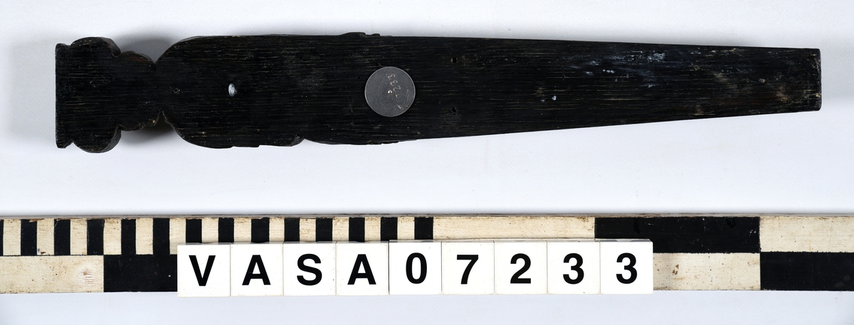Hermpilaster.
Liten skulpterad pilaster föreställande skäggig herm under joniskt kapitäl.
Huvudet är vridet mot vänster. Hermen är insvept i en mantel som hålls fast med vänster hand framför magen. I höger hand håller figuren ett okänt föremål (blomsterkälk?) framför bröstet. Pilasterskaftet är prytt med stora frukter och blad, fasthängande vid en stängel som delvis täcker det nedåt avsmalnande skaftets ramverk. Baksidan är slät.
Skulpturen är mycket välbevarad med sju spikhål.

Text in English: Small sculpted pilaster with a bearded Herm beneath an Ionic capital.
The head of the figure is turned to the left. The Herm is enveloped in a mantle, held fast with the left hand in front of its stomach. Its right hand holds an unknown object (a bunch of flowers?) in front of its breast. The shaft of the pilaster is decked with large fruit and leaves hanging from a stalk which partly cover the framing of the tapering shaft. Its back is flat.
The sculpture is very well preserved.