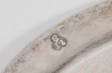 Oblatdisk i sølv. I diskens senter er et gullforgylt pattéekors i en sirkel risset inn. På diskens bakside er et våpenskjold risset inn. Trolig generalmajor Hausmanns. Se HM.00544.