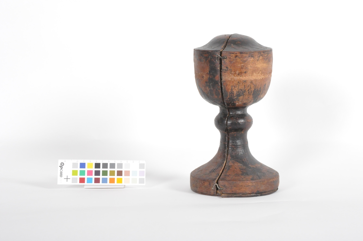 Alterkalk i sølv. Begeret er enkelt utformet med glatte sider og har innrisset som dekor et våpenskjold (antatt Hausmanns). Stetten er sekskantet og avbrutt av en disk som stikker ca 2 cm utenfor stetten. Under disken har stetten en dekorativ bård med to buedne fliker på hvar flate på stetten. Stetten ender opp i en fot som er formet som en blomst med seks kronblader.