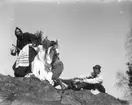 Ester och John Bauer tillsammans med vänner vid påsktid. Den ena, utklädd till häxa, sitter på en kvast på väg till Blåkulla enligt traditionen.