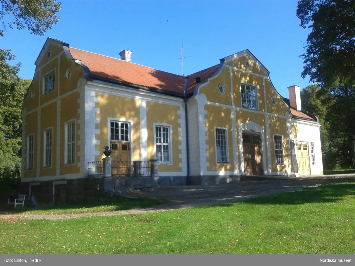 Livstallet och Vagnsflygeln är de två senast tillagda flyglarna i herrgårdsmiljön. Vagnsflyglens uppförande påbörjades 1903 och byggnaden stod klar 1905. Redan året efter började ett rum i byggnadens västra del att inredas för gårdens bibliotek. Av någon anledning bestämmer man sig istället för att flytta gårdskontoret från Södra flygeln till Vagnsflygeln. Vid samma tid som gårdskontoret flyttar in i Vagnsflygeln köps en personbil in till gården och 1912 inreds den östra delen av Vagnsflygeln som ”bilstall” och en ny större port sätts in.

På ett äldre fotografi på vagnsflygelns södra fasad syns ett takfönster i byggnadens västra del. Fönstret har fungerat som ljusinsläpp till vinden, trapphuset och gårdskontoret. Från gårdskontoret hämtade gårdens arbetare ut sin lön från bokhållaren och inspektören. Bokhållaren hade sin bostad i ett rum ovanför gårdskontoret. I vagnshallen stod gårdens finare vagnar. Förutom bokhållarens bostad fanns, på vinden, två andra lägenheter.

Byggnaden inrymmer:
1 st lägenhet för åretruntboende.
En utställningshall.
Tidigare mangelbod, nu linneförråd för uthyrningsrummen.
Panncentral till Vagnsflygeln och Norra/Södra flygeln.
Garage och förrådsutrymmen.