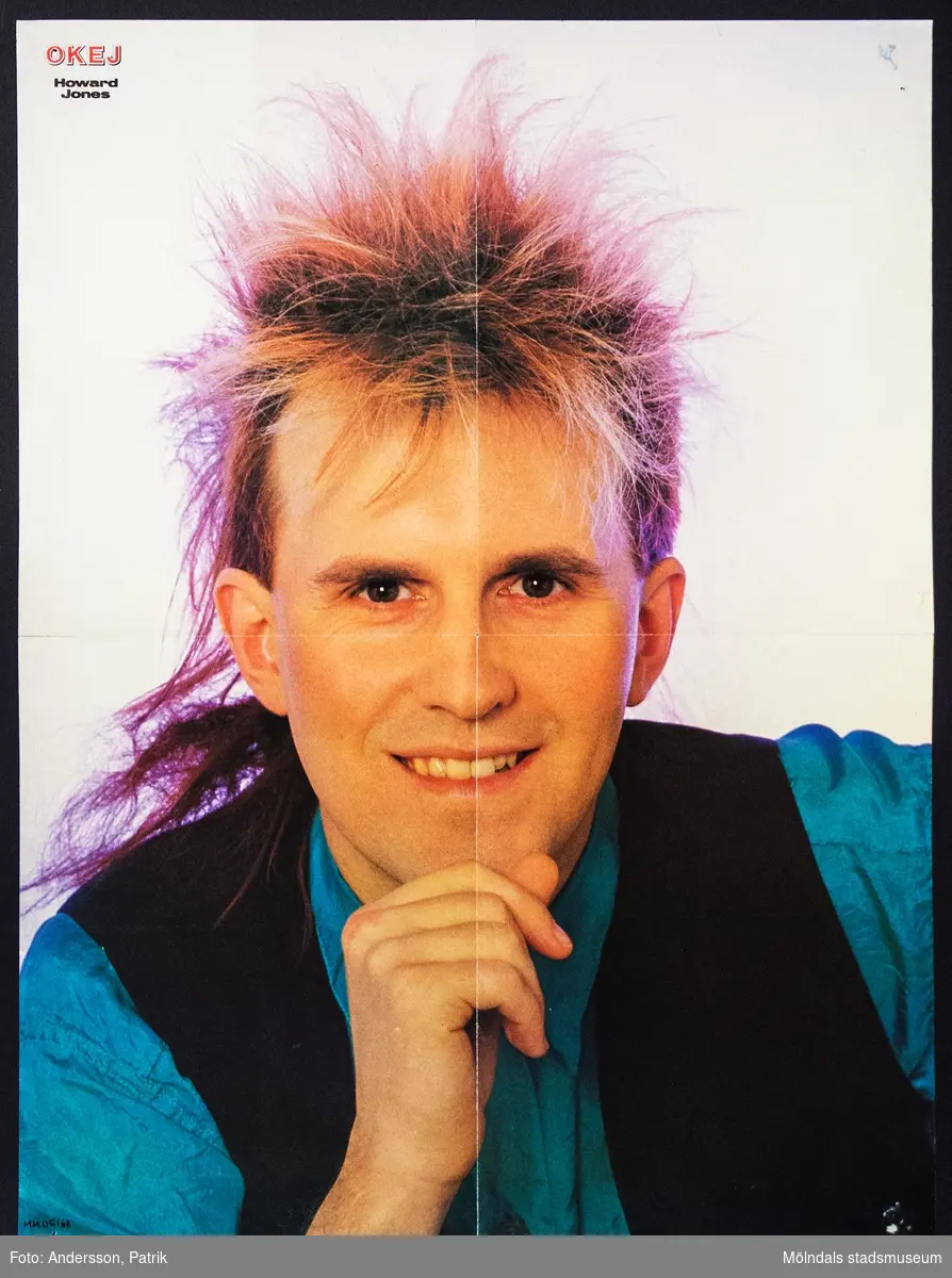 Poster från tidningen Okej, Nr. 9 1985, pris 
11,75 kr. 

Postern är dubbelsidig. 
På posterns ena sida finns  Howard Jones, brittisk sångare som fick sitt genombrott 1984 med låtarna "New Song", "What Is Love?", "Hide And Seek" och "Pearl In The Shell". 

På andra sidan av postern finns: Kiss, en amerikansk rockgrupp som fick sitt stora genombrott i mitten av 1970-talet och är fortfarande aktiva idag.

Tidningen Okej var en poptidning som gavs ut första gången 1980. Den gjorde succé under 1980-talet och räknas som Sveriges största poptidning. Det som gjorde tidningen speciell var blandningen mellan hårdrock och svensk popmusik. Både killar och tjejer läste tidningen. Sista nummret av tidningen Okej gavs ut 2010.