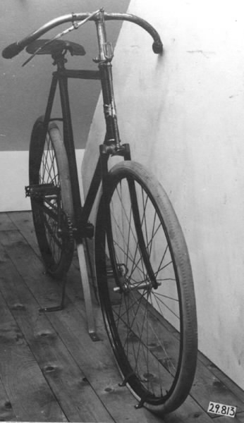 Cykel av stålrör. Diamond-ram. Lädersadel på metall-stomme och stavfjädrar, nedsvängt styre med skinnhandtag. Hjul av stålfälgar på suspensionsekrar. Luftfyllda gummidäck. Bakaxeln på vänster sida förlängd till fotsteg. Kedja av 2,3 cm långa länksidor förenade medelst massiva mellanstycken. Svart, styre och framgaffelkrona förkromade. På styrrörets framsida korsformig kartusch i metall mellan två, mot varandra vända nymånar. Text: "CRESCENT".