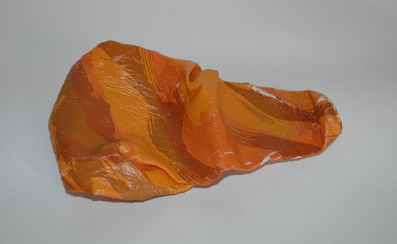 Crescent-cykel med racerstyre från Monark-Crescent AB i Varberg a) Orangefärgad 12-växlad damcykel med racerstyre/bockstyre. Däcken är ej original. Märkning: "306 Fashionline" Sadel: "Selle Royal".
b) Sadelskydd i skinn, 25x13 cm. c) Sadelskydd i orangefärgad plast, 24x13 cm. d) Röd/gul packrem med vita plasthakar, längd 52 cm. e) Ventil, metall, längd 2,5 cm.
f) Glasögon med vita skalmar och orangefärgade bågar, 50x130 mm, 1980-tal.