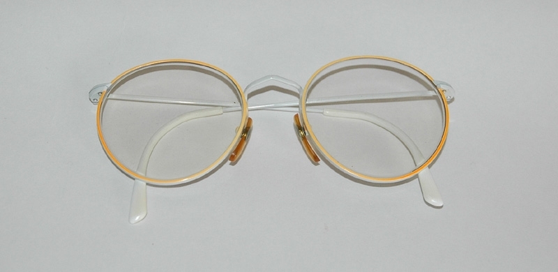 Crescent-cykel med racerstyre från Monark-Crescent AB i Varberg a) Orangefärgad 12-växlad damcykel med racerstyre/bockstyre. Däcken är ej original. Märkning: "306 Fashionline" Sadel: "Selle Royal".
b) Sadelskydd i skinn, 25x13 cm. c) Sadelskydd i orangefärgad plast, 24x13 cm. d) Röd/gul packrem med vita plasthakar, längd 52 cm. e) Ventil, metall, längd 2,5 cm.
f) Glasögon med vita skalmar och orangefärgade bågar, 50x130 mm, 1980-tal.