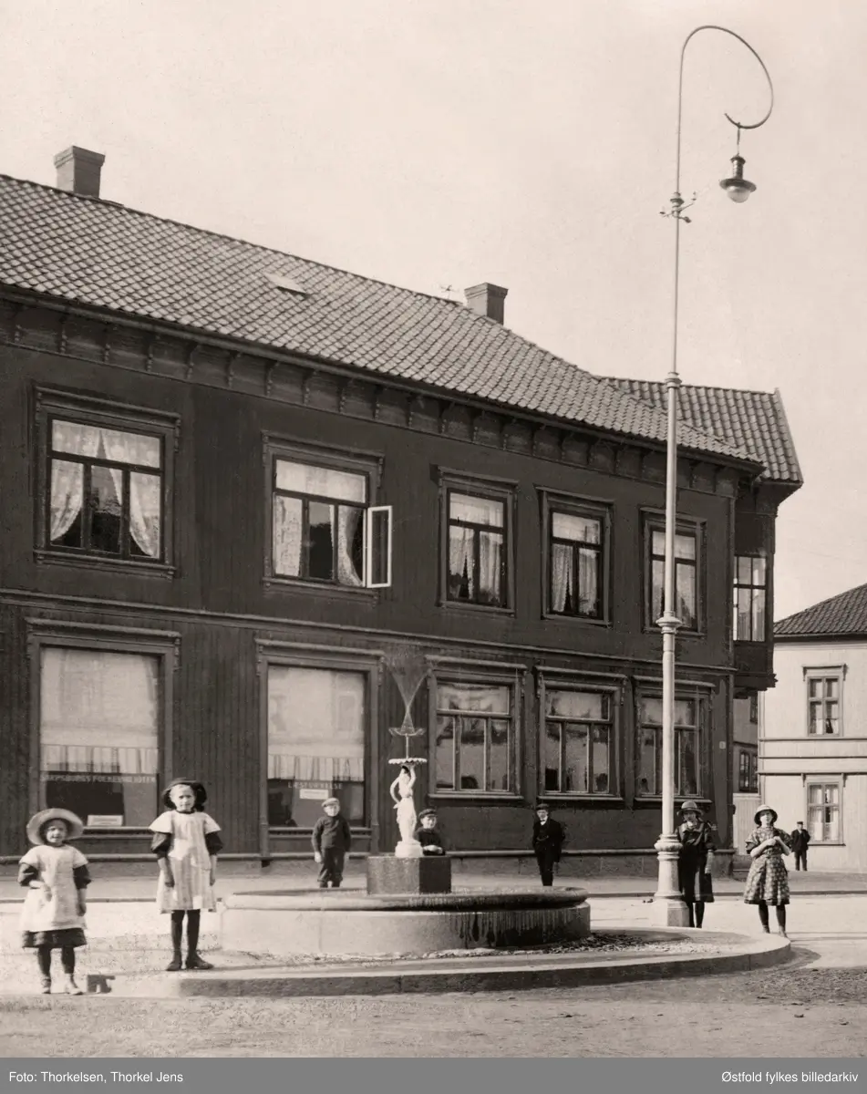 Lilletorget i Sarpsborg , prospektkort ca. 1900. Sett langs Glengsgata.
Fontene av den romerske gudinne Flora, oppført på Lilletorget i Sarpsborg 1897. Fontenen var en gave til byen fra kjøpmann Mikael Lund, Fontenen/figuren kan muligens være kjøpt i Riga (info 2016 Oddvar Sørbye), fundamantet var av granitt. I 1916 da statuen av Olav den Hellige til byjubileet på samnme sted  i 1916, ble fontenen flyttta til St. Hallvards plass. Kreditbanken til høyre. Bøndenes Hus til venstre, tidligere hotell.