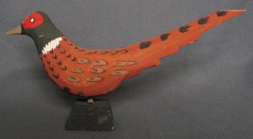 Fyra dekormålade fasaner.
a. Större fasan på 1 cm kort träben. Längd 300 mm. Stjärten avbruten.
b. Mindre fasan på ca 1 cm kort träben. Längd 200 mm.
c. Mindre fasan på högt, snett träben. 
d. Större fasan med två ståltrådsben. (Detta är troligen en kopia, både formen och färgen är annorlunda).
Fåglarna gjorda av Sven Dal, Pinkatorparn. De målades av olika kvinnor på bygden.
