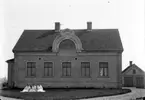 Villabygnad, tre damer poserar sittande på gräsmattan ca:1919
	Metallutfällning, repor, prickhål i emulsionen.