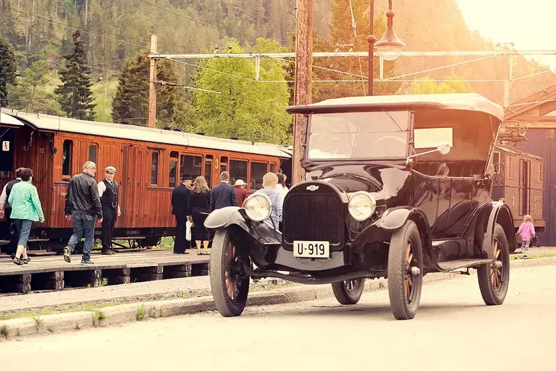 Veteranbil foran tog på Løkken stasjon