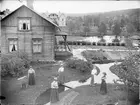 Översvämning, kvinnor utanför hus tillhörande Brunzells Pensionat, Rättvik, Dalarna 1909