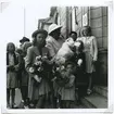 Arvprins Carl Gustaf i sin sköterska Ingrid Björnbergs famn anländer med sina systrar till Stadshotellet för lunch 1946-08-01.