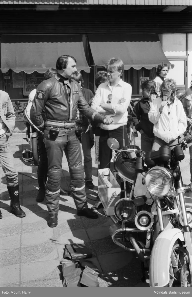Kållereds Motorklubb visar upp motorcyklar i Kållereds centrum, år 1984. "MC-polis Lennart Johansson i samspråk med Mc-klubbens ordförande Dennis Byström."

För mer information om bilden se under tilläggsinformation.