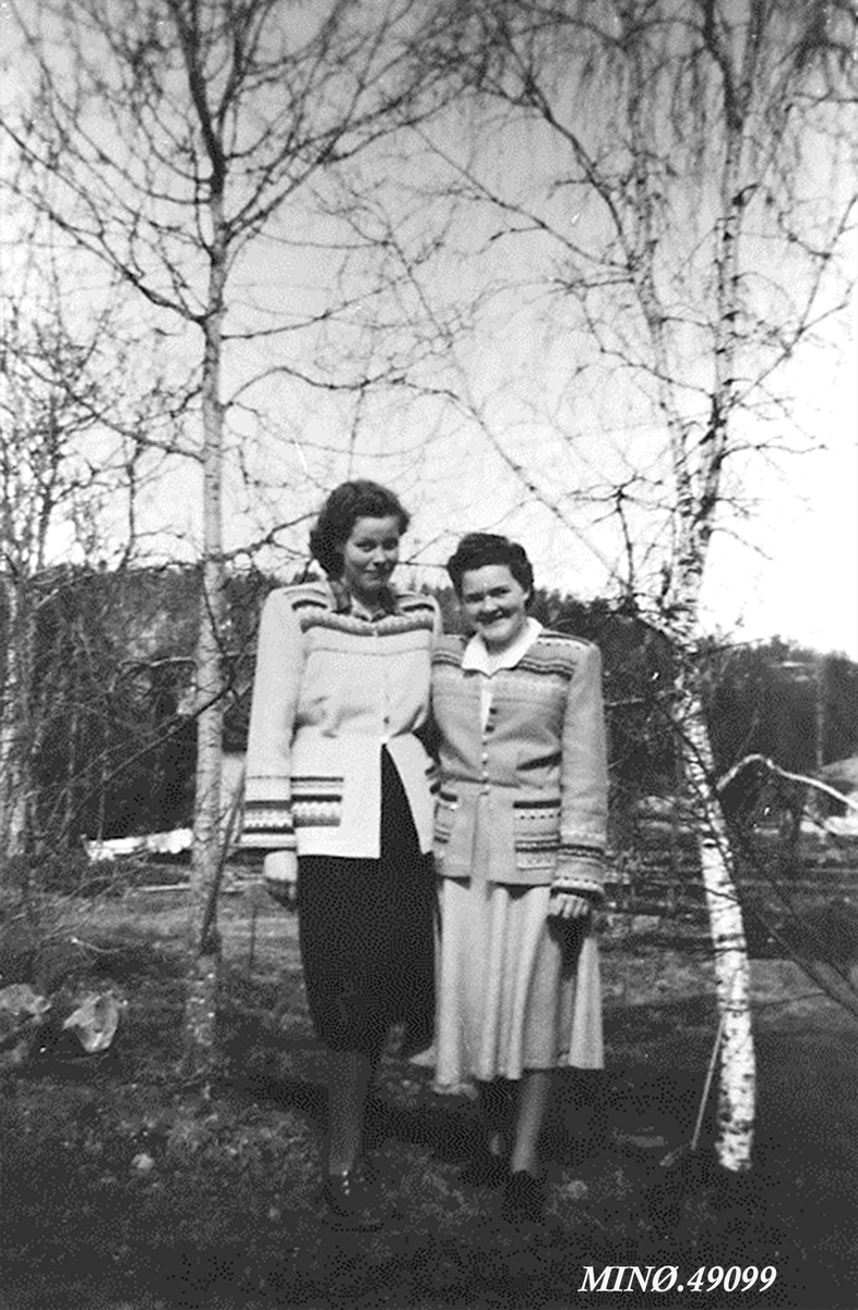 To damer viser fram Gripstad veveri-produkter. 